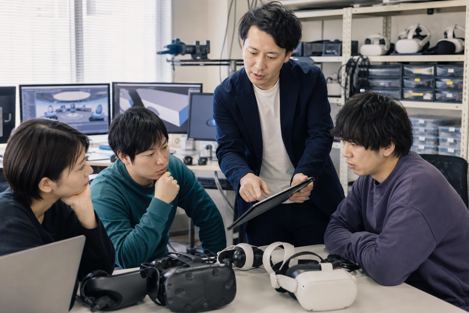 VR開発チームがヘッドセットや開発環境の引継ぎを確認する様子